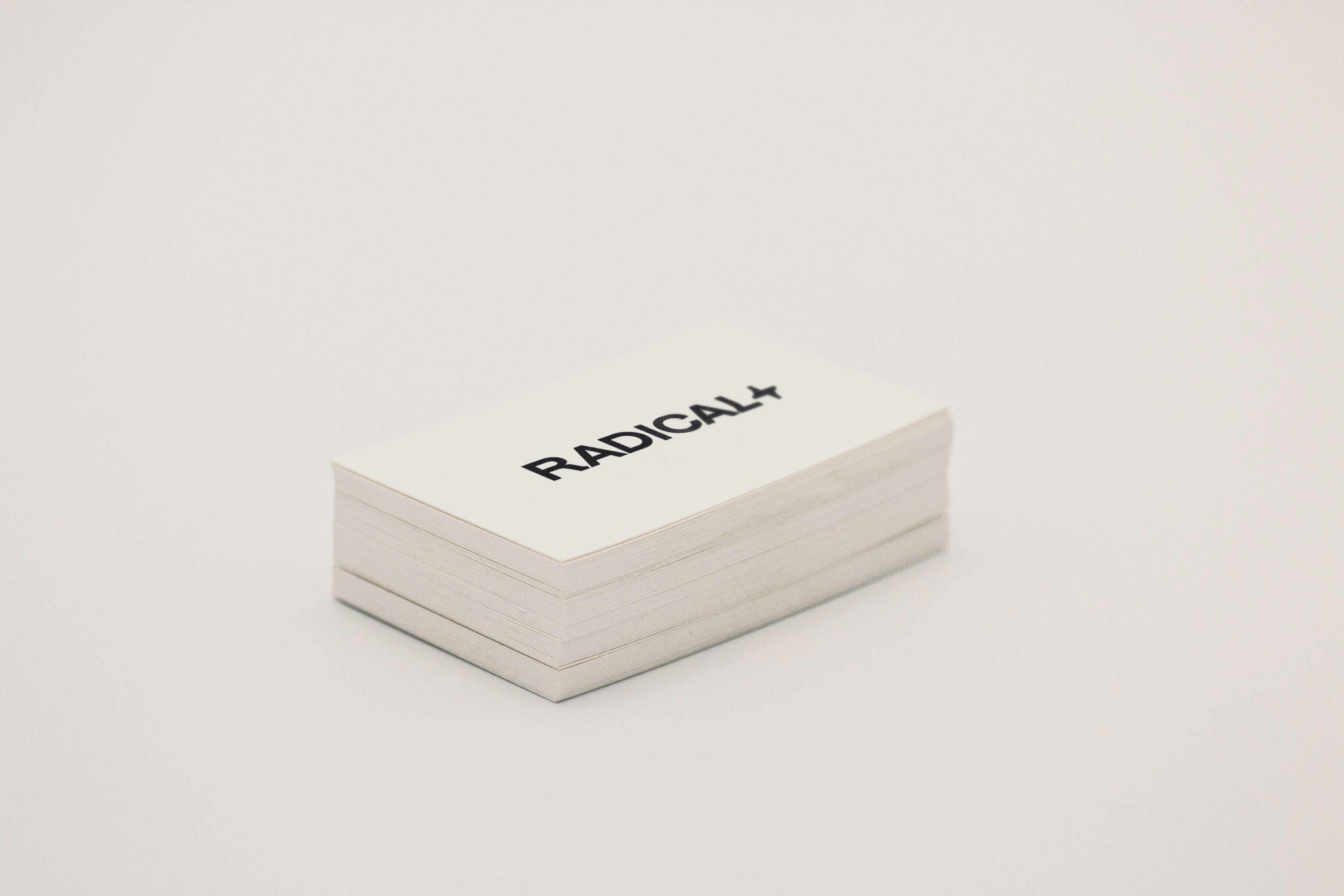Stack of Radical business cards with logotype on white surface